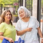 two older women out shopping in town and laughing together